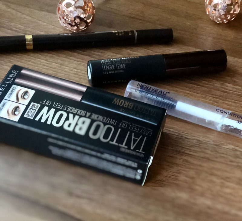 Flatlay product shot of Tom Ford Brow Sculptor in Espresso, Nouveau Lash Serum and Maybelline Tattoo brow